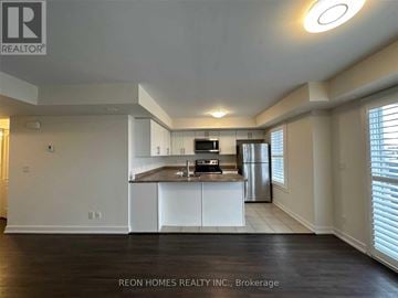 Markham (Cornell) townhouse for rent - A spacious kitchen with white cabinets and stainless steel appliances.