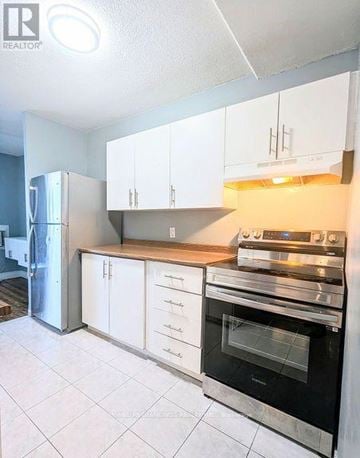 London South (South X) condo for rent - A kitchen with white cabinets and a black oven.