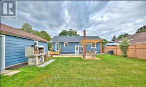 St. Catharines (Carlton/Bunting) apartment for rent - A blue house with a brown roof and a wooden deck in the backyard.