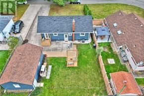 St. Catharines (Carlton/Bunting) apartment for rent - A house with a blue roof and a chimney is surrounded by other houses with red roofs.