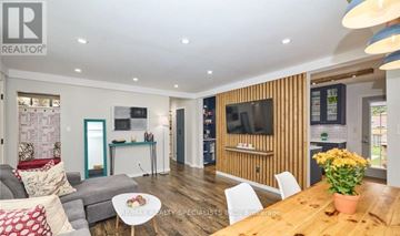 St. Catharines (Carlton/Bunting) apartment for rent - A living room with a grey couch and a wooden table.