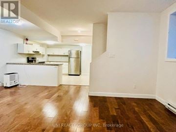 Ottawa townhouse for rent - A kitchen with white cabinets and a wooden floor.