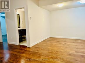 Ottawa townhouse for rent - A room with wooden flooring and a white wall with a doorway leading to another room.