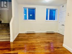Ottawa townhouse for rent - A room with wooden floors and two windows with blue blinds.