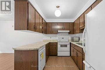 Guelph (Kortright West) apartment for rent - A kitchen with wooden cabinets and a white fridge.