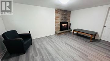 Markham (Royal Orchard) apartment for rent - A living room with a black chair and a fireplace.