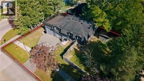 Kitchener apartment for rent - A large house with a grey roof is surrounded by trees.
