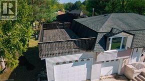 Kitchener apartment for rent - A house with a white garage door is surrounded by trees.