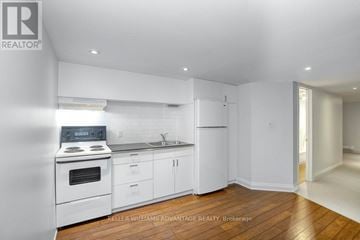 Toronto (Dovercourt-Wallace Emerson-Junction) apartment for rent - A white kitchen with wood floors and a stove top oven.
