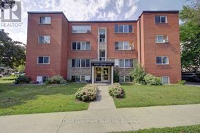 Burlington (Brant) multi-family for rent - A red brick building with a green lawn in front.