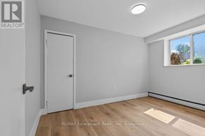 Burlington (Brant) multi-family for rent - A room with a white door and a window with a view of trees outside.