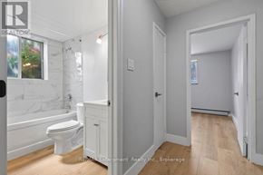 Burlington (Brant) multi-family for rent - A white bathroom with a toilet, tub, and sink.