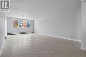 Burlington (Brant) multi-family for rent - A large empty room with a window showing a view of a building outside.
