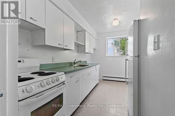 Burlington (Brant) multi-family for rent - A white kitchen with a stove top oven and a refrigerator.