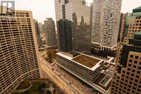 Toronto (Waterfront Communities) condo for rent - A view of a cityscape with a building in the foreground and other buildings in the background.
