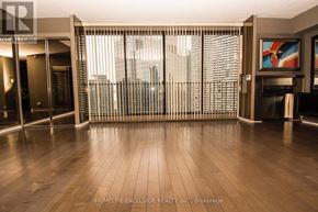 Toronto (Waterfront Communities) condo for rent - A room with wooden floors and a large window with blinds.