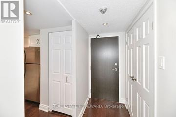 Toronto (Cabbagetown-South St. James Town) condo for rent - A brokerage sign is on the wall of a white hallway.