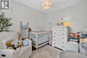 Toronto (East York) apartment for rent - A baby nursery with a white crib, a changing table, and a teddy bear on the couch.