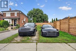 Toronto (East York) apartment for rent - Two cars are parked in front of a house with a sign that says "REALTOR".