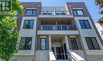 Toronto (Mimico) townhouse for rent - A multi-story building with a balcony on the second floor.