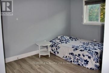 Woodstock (Woodstock - South) townhouse for rent - A bedroom with a bed and a small table.