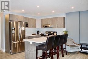 Woodstock (Woodstock - South) townhouse for rent - A modern kitchen with a refrigerator, sink, and dining table.