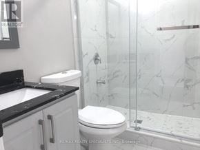 Milton (Walker) apartment for rent - A white toilet sits in a bathroom with a marble shower.