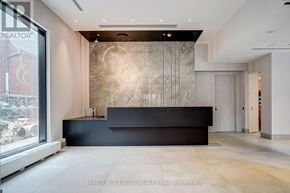 Toronto (North St. James Town) condo for rent - A reception area with a black counter and a large window.