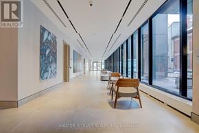 Toronto (North St. James Town) condo for rent - A long hallway with a bench and windows on one side.