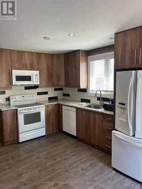 Bradford West Gwillimbury (Bradford) apartment for rent - A kitchen with white appliances and wooden cabinets.