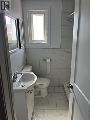 Bradford West Gwillimbury (Bradford) apartment for rent - A bathroom with a toilet, sink, and a window.