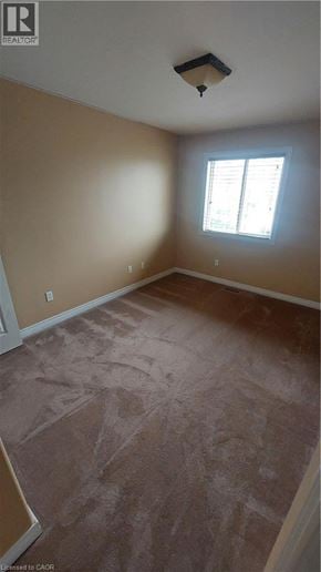 Binbrook townhouse for rent - A room with a window and a light brown carpet.