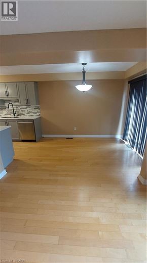 Binbrook townhouse for rent - A kitchen with wooden floors and a hanging light fixture.