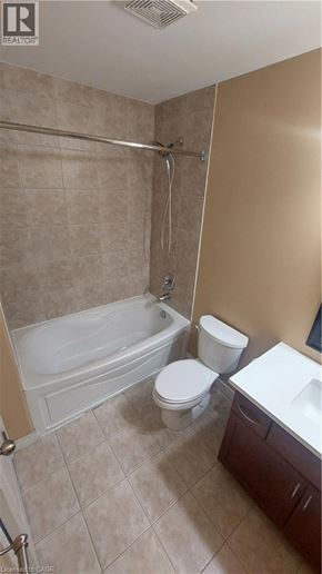 Binbrook townhouse for rent - A beige bathroom with a white toilet and a white sink.
