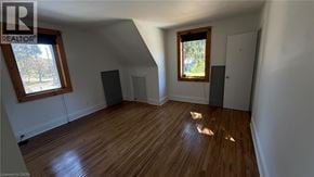 Burlington apartment for rent - A room with wooden floors and white walls, with a window and a door visible.