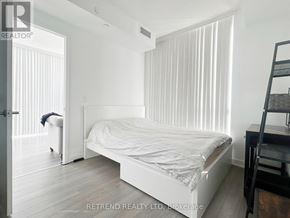Toronto (Willowdale West) condo for rent - A bedroom with a bed, a ladder, and a person in the background.