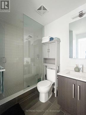 Toronto (Willowdale West) condo for rent - A white toilet sits in a bathroom with a glass shower door.