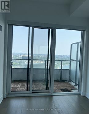 Toronto (Mimico) condo for rent - A room with a view of the city through large windows.