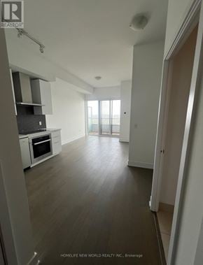Toronto (Mimico) condo for rent - A spacious, empty room with wooden floors and white walls.