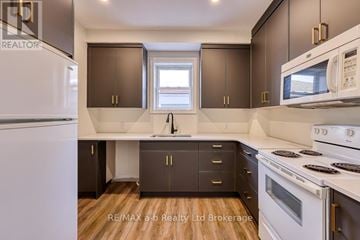 Woodstock (Woodstock - South) apartment for rent - A kitchen with a white refrigerator, brown cabinets, and a white stove top oven.