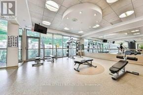 Toronto (Bendale) condo for rent - A gym with a flat screen TV, treadmill, and weights.