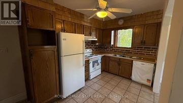 Burlington (Lasalle) apartment for rent - A kitchen with wooden cabinets and a white refrigerator.