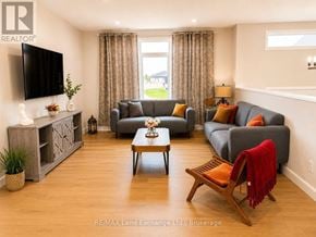 Saugeen Shores apartment for rent - A living room with a grey couch, a wooden coffee table, and a television on the wall.