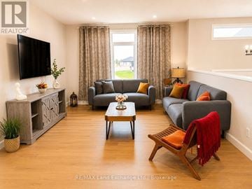 Saugeen Shores apartment for rent - A living room with a grey couch, a wooden coffee table, and a television on the wall.