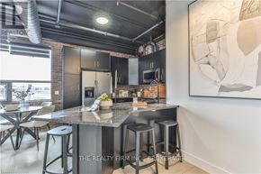 London North (North E) condo for rent - A modern kitchen with a large island and stools.