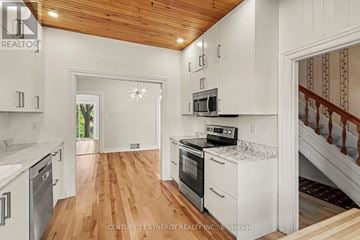 Ottawa apartment for rent - A kitchen with white cabinets and a wooden ceiling.