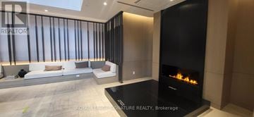 Mississauga (City Centre) condo for rent - A modern living room with a fireplace and a sofa.