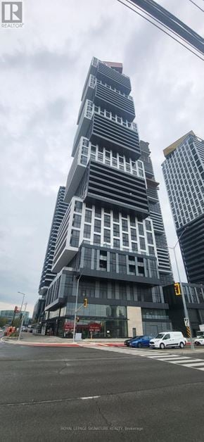 Mississauga (City Centre) condo for rent - A tall building with a unique design stands out in the cityscape.