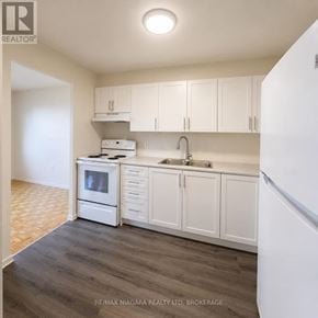 Midland multi-family for rent - A kitchen with white cabinets and a white refrigerator.