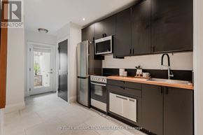 Toronto (The Beaches) apartment for rent - A modern kitchen with dark brown cabinets and stainless steel appliances.